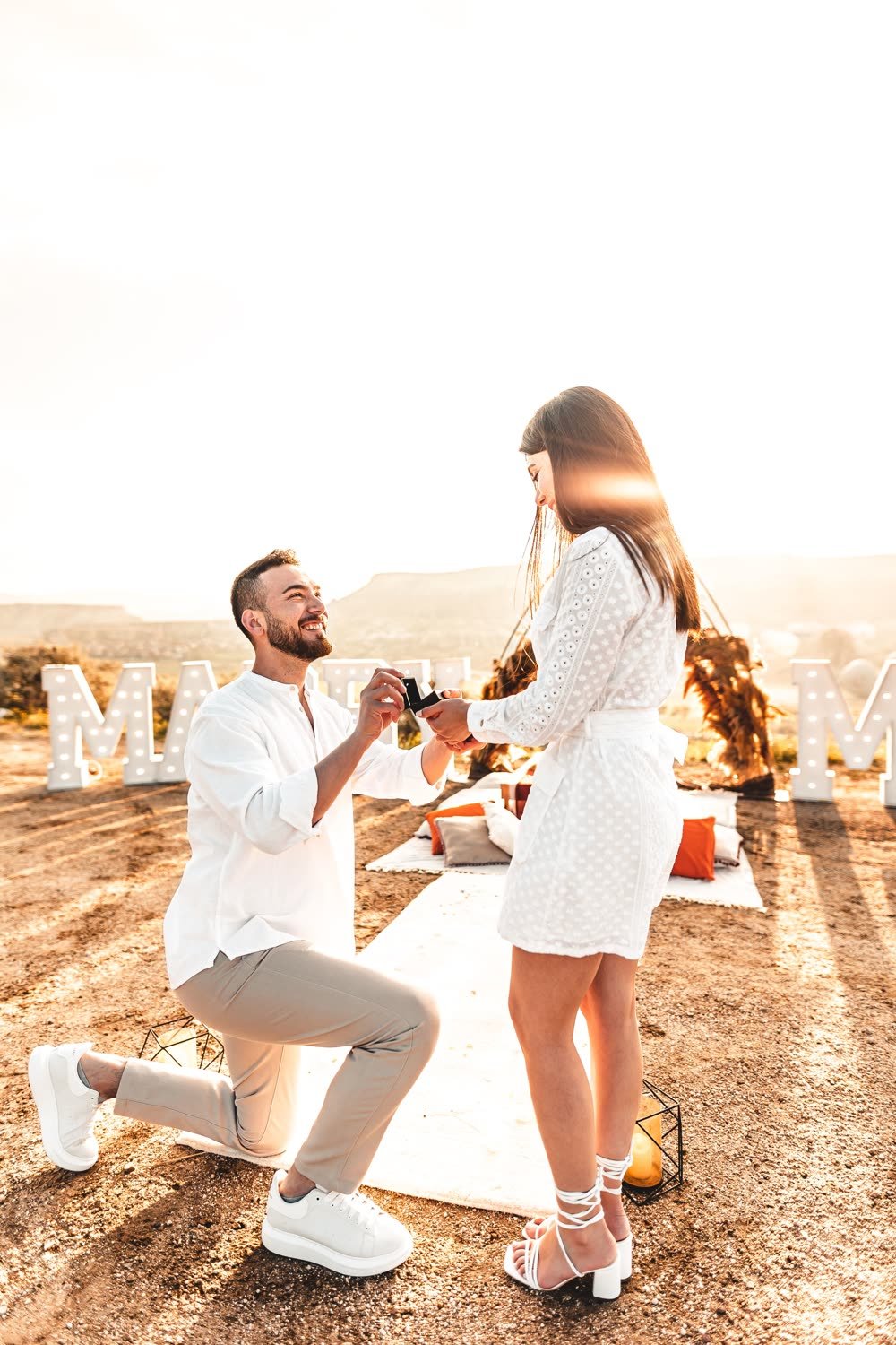 Heiratsantrag bei Sonnenuntergang, er kniet mit Ring